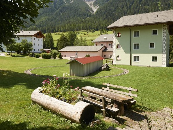 Wiese mit Häusern und Bank