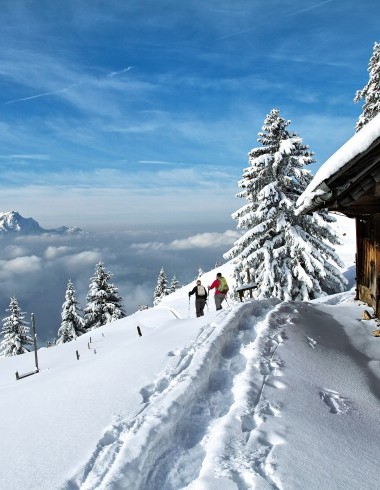 Schneeschuhläufer neben Haus bedeckt mit Schnee