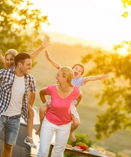 Eltern tragen Kinder auf dem Rücken