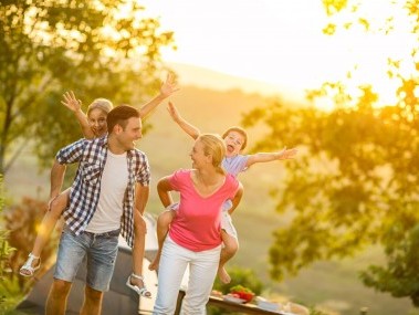 Eltern tragen Kinder auf dem Rücken