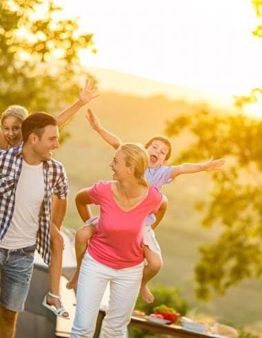 Eltern tragen Kinder auf dem Rücken