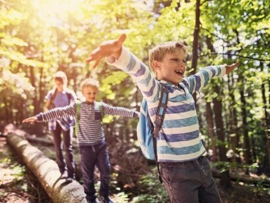 Kinder balancieren über Baumstamm