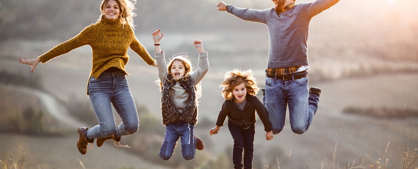 Glückliche Familie springt gleichzeitig hoch