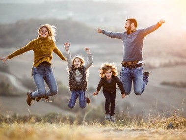 Glückliche Familie springt gleichzeitig hoch