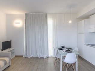 Wohnzimmer mit Essbereich - Capo Falcone Charming Apartments