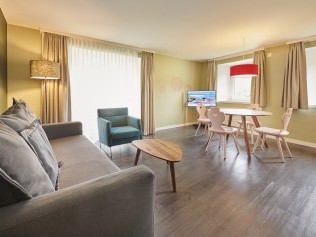 Wohnzimmer mit Essbereich - Reka-Ferienanlage Chesa Engadina Madulain