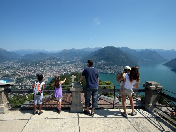 Familie geniesst Sicht über das ganze Tessin vom Monte San Salvatore