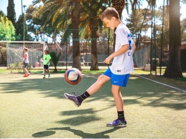 Junge mit weissem Shirt jongliert mit weissem Ball